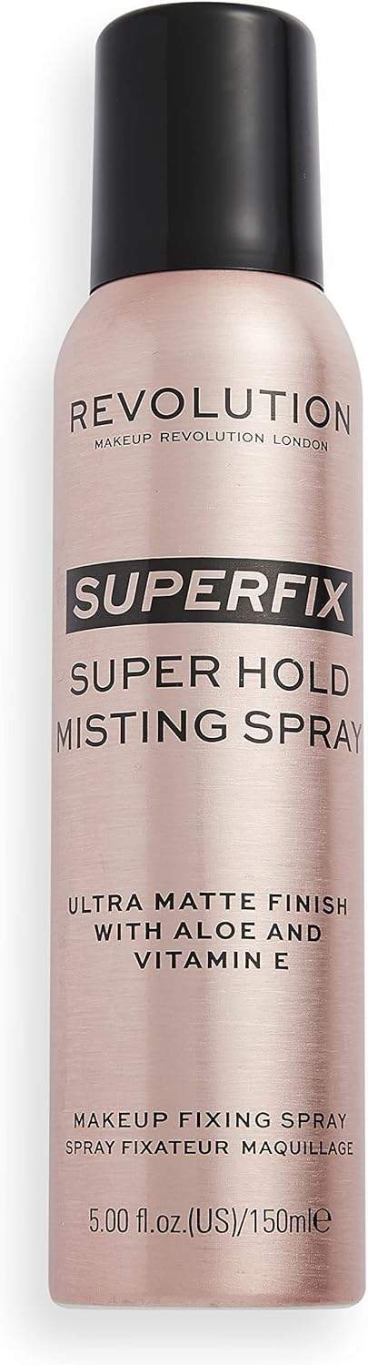 Złoty spray Revolution Beauty na czarnym tle